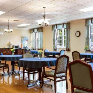A spacious dining area featuring elegant tables and chairs, bathed in natural light from large windows.