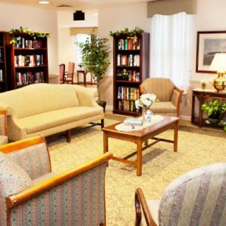 A cozy living room with comfortable seating, bookshelves, and elegant decor.