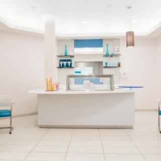 A modern and minimalist reception desk area with white and blue accents.
