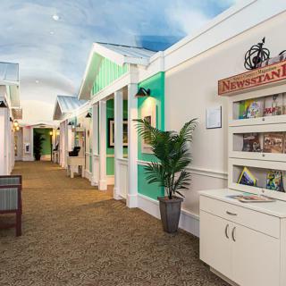 A brightly lit indoor corridor with colorful walls and decorative plants.