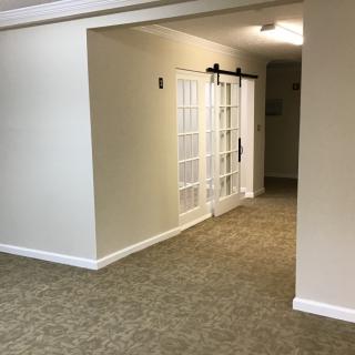 Spacious hallway with carpet flooring and a sliding glass door.