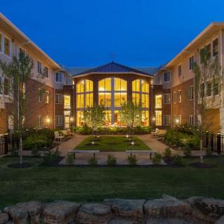 A well-lit modern building with a landscaped courtyard at night.