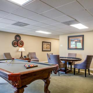 A recreational room featuring a pool table and a seating area with artwork on the walls.
