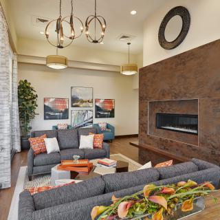 A modern living room featuring stylish furniture, a large fireplace, and contemporary lighting.