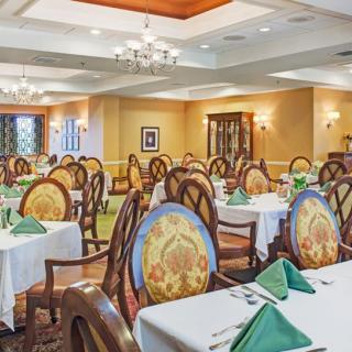 An elegant dining room with neatly arranged tables and chairs, featuring a warm and inviting decor.