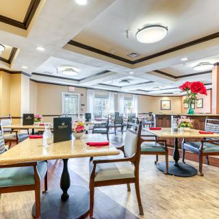 An elegant restaurant dining area with neatly arranged tables and chairs, featuring tasteful decor and ample natural light.