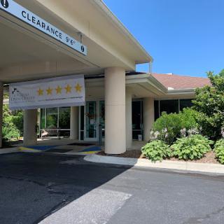 Entrance to a facility featuring signage and a well-maintained landscape.
