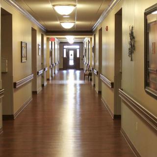 A well-lit hallway with wooden floors and decorated walls.