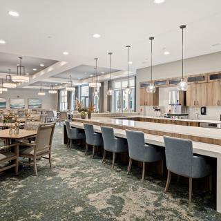 A spacious and modern interior dining area with a large kitchen island and stylish lighting.