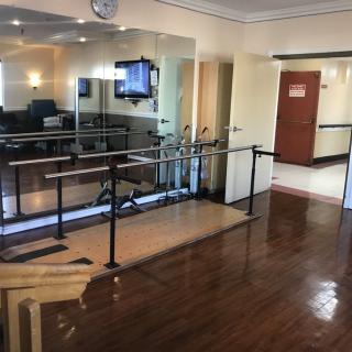 A physical therapy room equipped with parallel bars for rehabilitation exercises.