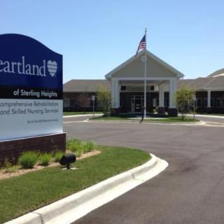 A nursing home facility with a visible sign and an American flag at the entrance.