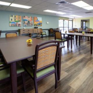 An empty dining area with neatly arranged tables and chairs, featuring a warm and inviting interior.