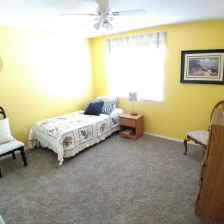 A cozy bedroom with yellow walls and a single bed.