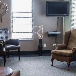 A cozy living room with chairs, a television, and decorative elements.