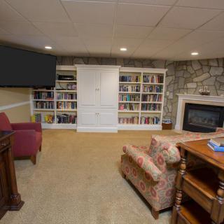 A cozy living room with bookshelves, a fireplace, and comfortable seating.