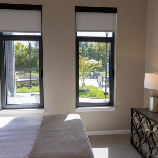 A minimalist bedroom with large windows allowing natural light to fill the space.