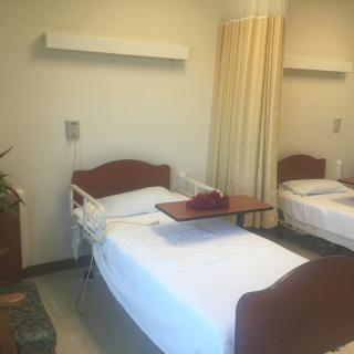 A clean and organized hospital room with a bed and curtain divider.