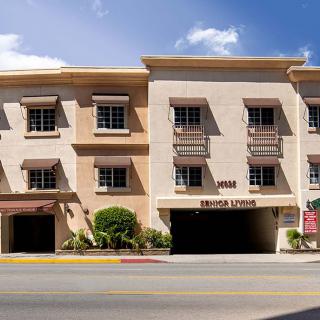 A street view of a commercial building with multiple windows and awnings.