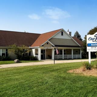 A retirement home with a well-maintained lawn and clear signage.