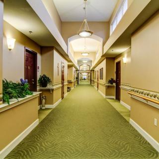 A well-lit, carpeted hallway with multiple doors and decorative lighting.