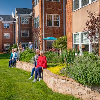 Residents enjoying a sunny day in the garden of their residential community.