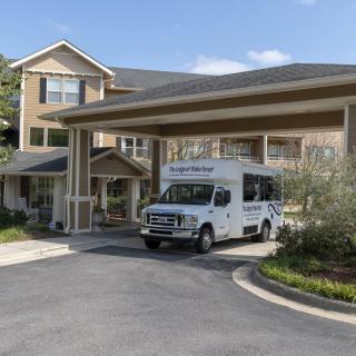 A van parked under the entrance of a building with a covered walkway.