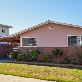 A single-story suburban house with a front yard on a sunny day.