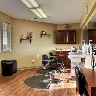 A well-lit barbershop interior with styling chairs and mirrors.