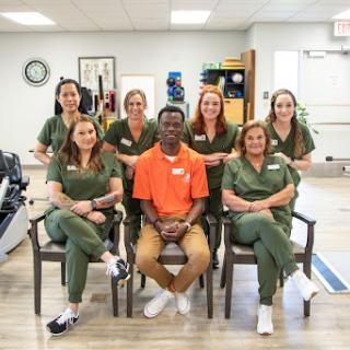 A dedicated team of healthcare professionals posing for a group photo in a rehabilitation center.