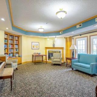 A cozy living room with comfortable seating, a fireplace, and bookshelves.