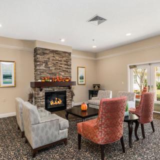 A cozy living room with a central fireplace, comfortable seating, and elegant decor.