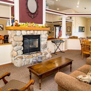 A cozy living room featuring a stone fireplace, comfortable seating, and warm decor.