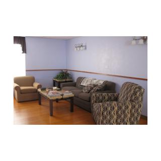 A cozy living room with sofas and armchairs arranged around a central coffee table.