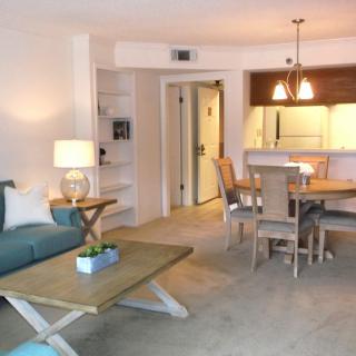 A modern living room and dining area with natural lighting and contemporary furnishings.