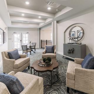 A modern living room with comfortable armchairs, a central coffee table, and decorative elements.