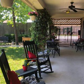 A peaceful patio with rocking chairs and lush greenery.