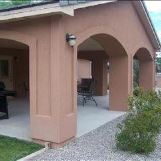 A house patio with arches and a garden.