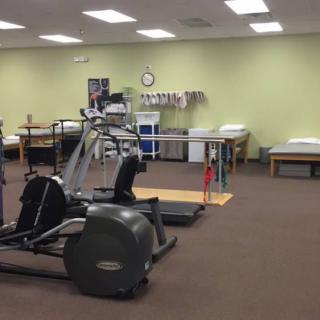 A room equipped with various exercise machines for physical therapy.