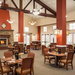 A cozy restaurant interior with a warm fireplace and neatly arranged dining tables.