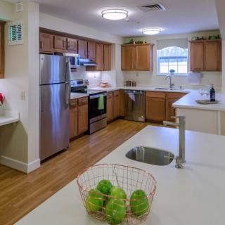 A modern kitchen with wooden cabinets and stainless steel appliances.