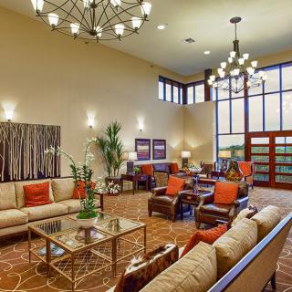 A spacious and elegant lobby with modern furniture and chandeliers.