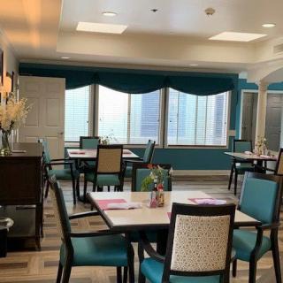 A well-lit dining room with neatly arranged tables and chairs.