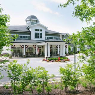 A large, elegant building surrounded by lush greenery and trees.