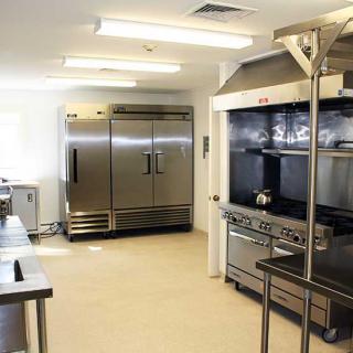 A spacious commercial kitchen equipped with stainless steel appliances and industrial-grade equipment.