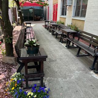 A serene outdoor area featuring benches and vibrant flowers along a walkway.