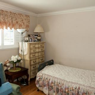 A cozy bedroom with a single bed, dresser, and decorative items.