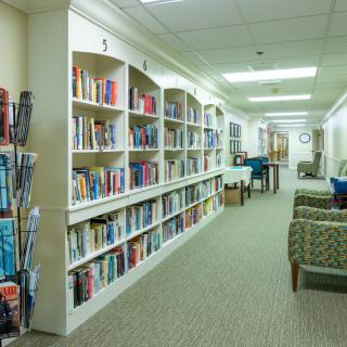 A quiet library hallway with bookshelves filled with books and a comfortable seating area.