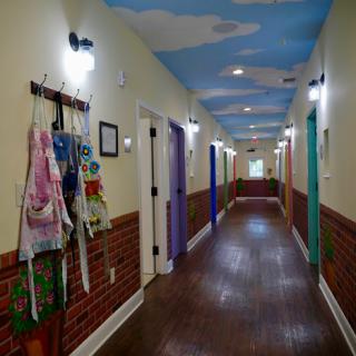 A vibrant hallway featuring colorful doors and a whimsical painted ceiling.