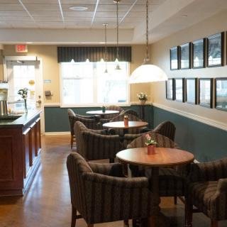 A cozy cafe interior with seating and tables.