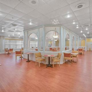 A spacious and well-lit restaurant interior featuring elegant decor and comfortable seating arrangements.
